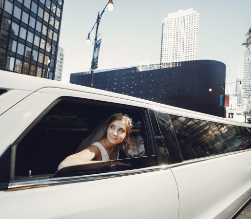 Une mariée élégante en limousine pour un jour unique Une mariée souriante regardant à travers la fenêtre d’une limousine blanche lors de son mariage.