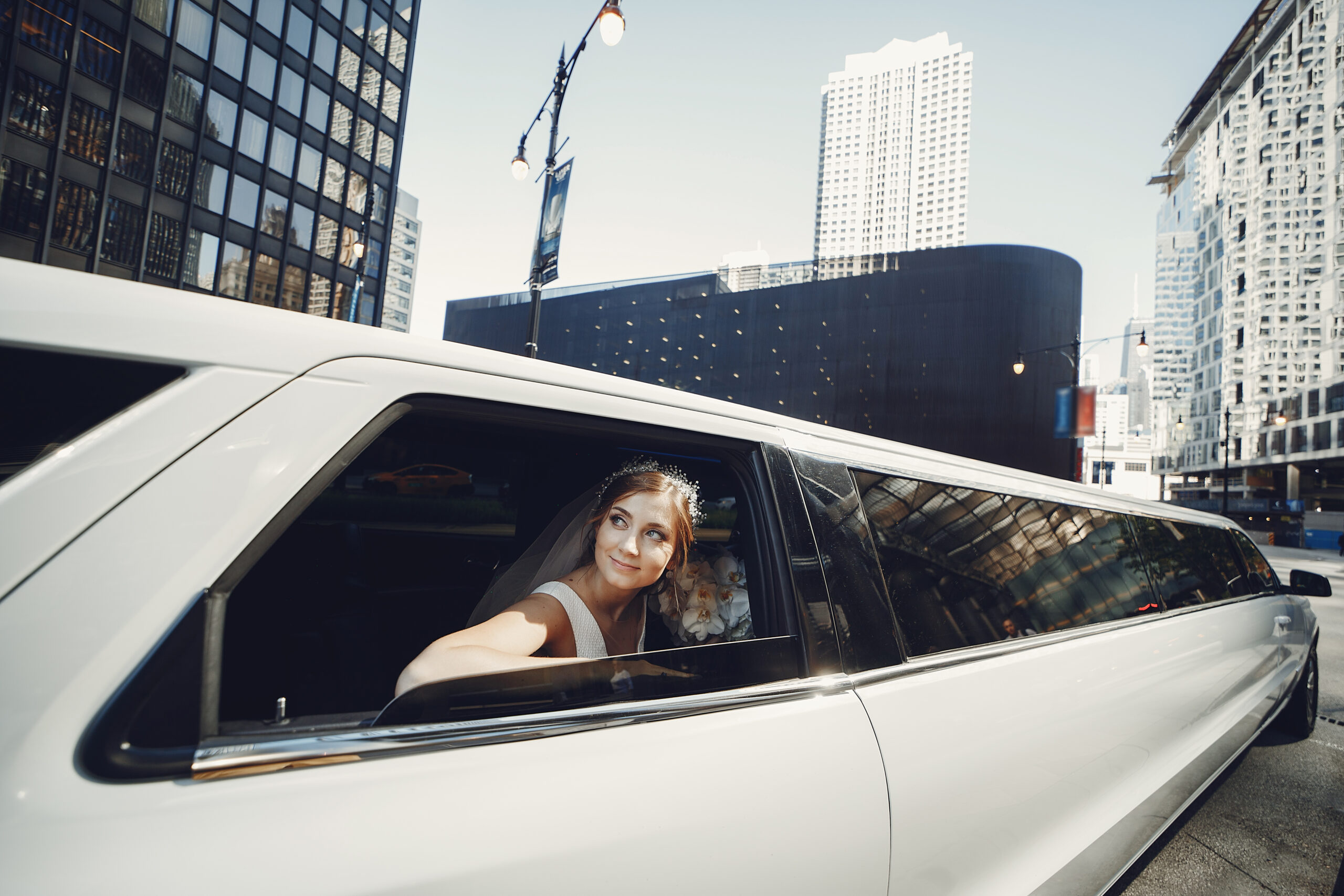 Une mariée élégante en limousine pour un jour unique Une mariée souriante regardant à travers la fenêtre d’une limousine blanche lors de son mariage.