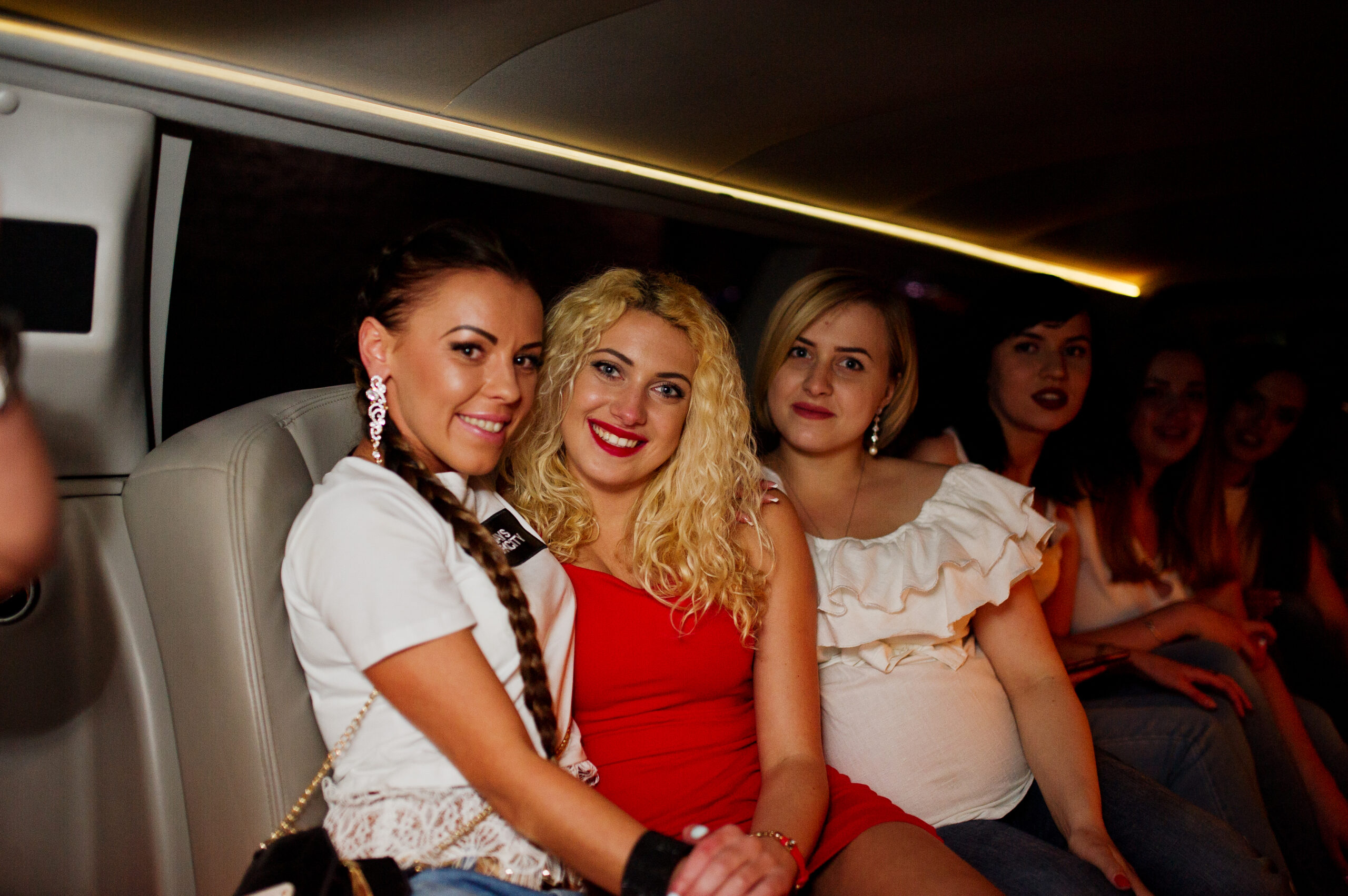 Un groupe de femmes souriantes à l’intérieur d’une limousine lors d’une soirée festive.